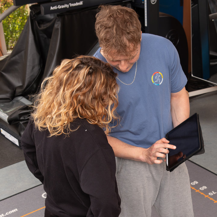 Mann in Alter-G Laufband mit Betreuer